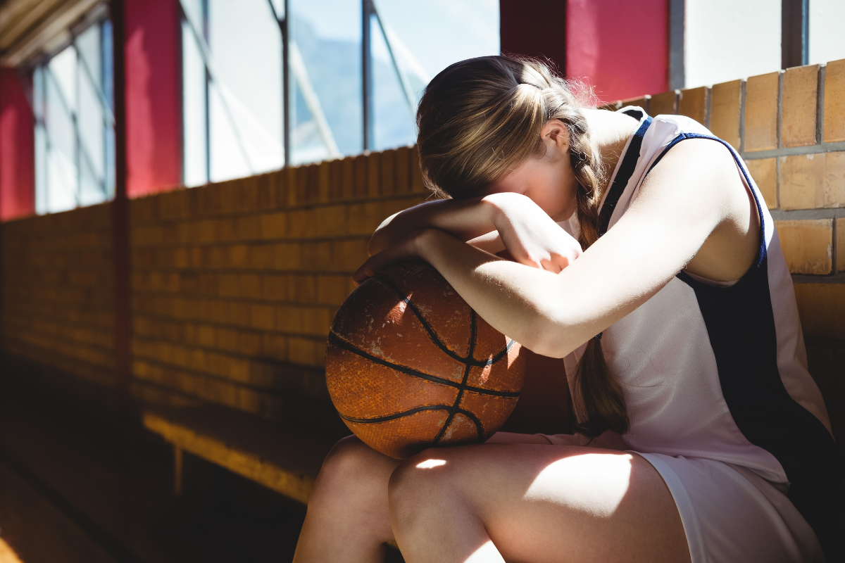 A young basketball player experiencing mental health struggles looking sad and feeling depressed in Austin, Texas.